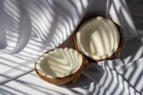 Tropical fruit concept, Two halves of fresh coconut on white fabric backgro.. Foto stock