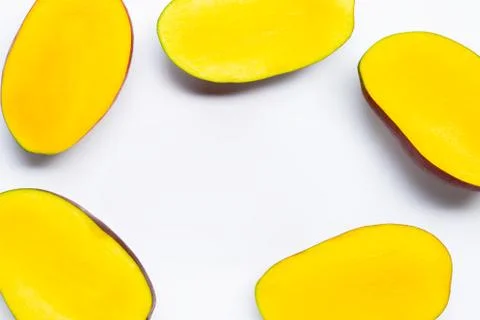 Tropical fruit, Frame made of mango slices on white background. Stock Photos