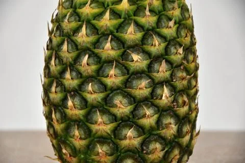 Tropical fruit pineapple, standing on a ceramic tile. Detail. Stock Photos