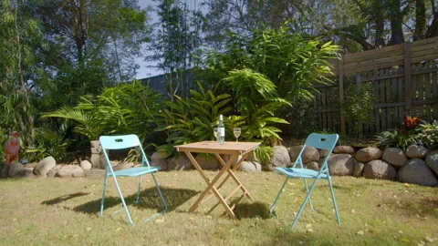 Tropical garden table setting with wine glasses and chairs Stock Footage 201367627