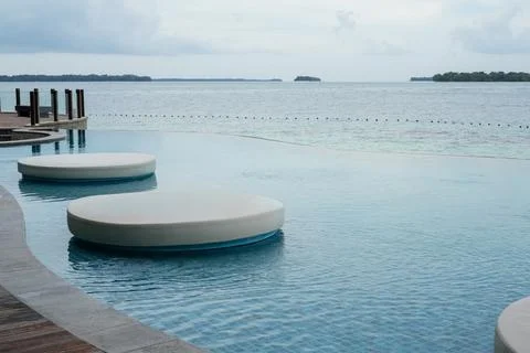 Tropical Infinity Pool Overlooking Calm Sea at Island Resort Stock Photos