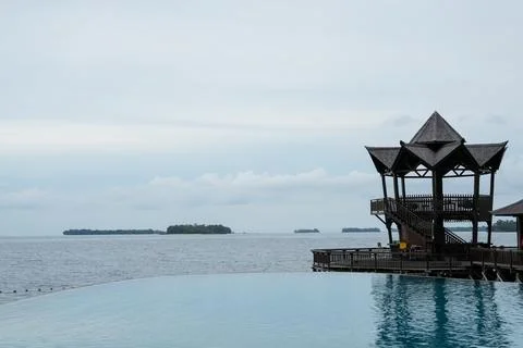 Tropical Infinity Pool Overlooking Sea and Wooden Pavilion Stock Photos
