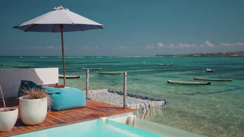 Tropical infinity pool overlooking the turquoise ocean, beachside resort Vídeos de archivo 341522745