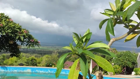 Tropical Infinity Pool View with Stormy Clouds and Lush Greenery Stock Footage 340465486