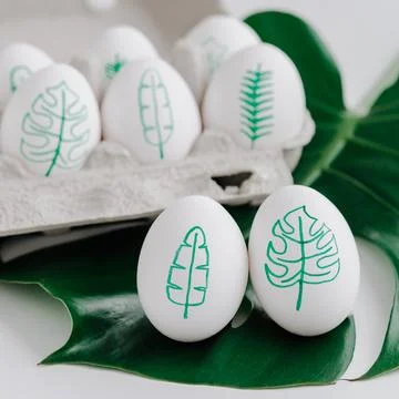 Tropical leaves drawings on easter eggs Stock Photos