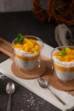 Tropical Mango Chia Seed Pudding in Glass Cups with Mint and Coconut Flakes Stock Photos