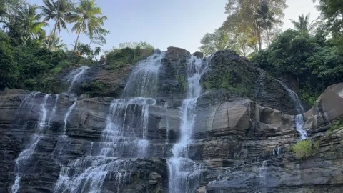Tropical Multi-Tiered Waterfall Cascading Down Rocky Cliff, Smooth Vertical Pan Stock Footage 324771054