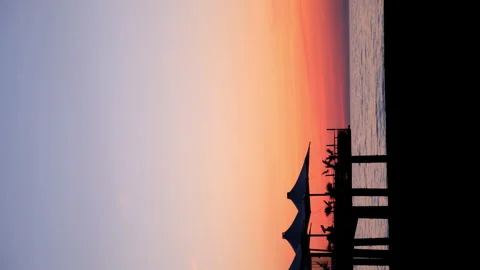 Tropical ocean beach with cafe on beach at dark sunset with purple orange sky. Stock Footage 256141681