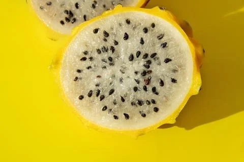 Tropical pitaya dragon fruit in section white flesh with black seeds yellow b Stock Photos