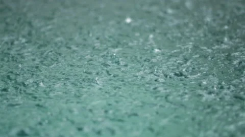 Tropical rain drops falling onto the surface of a swimming pool Stock Footage 222066393