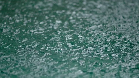Tropical rain drops falling onto the surface of a swimming pool. Slow motion Stock Footage 222783273