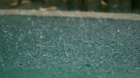 Tropical rain drops falling onto the surface of a swimming pool. Slow motion 動画素材 228012959
