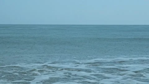 Tropical rain falling on ocean waves Видео 335469290