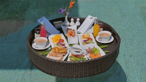 Tropical resort breakfast served on floating tray in luxury pool, 库存影片 278866127