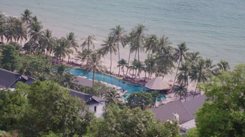 Tropical Resort Pool and Ocean Shoreline High Angle Wide Shot Stock Footage 337533085