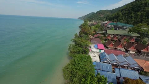 Tropical resort town nestled between lush green hills and turquoise ocean waters Stock-Footage 304501416