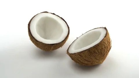 Tropical ripe coconut split in two halves rotating on a white background Stock Footage 71178780