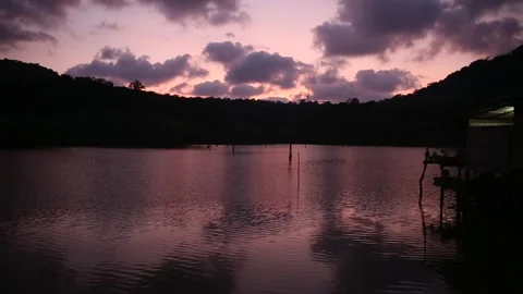 Tropical sea bay backlit by the declining sun with purple sunset sky. Stock Footage 277872489