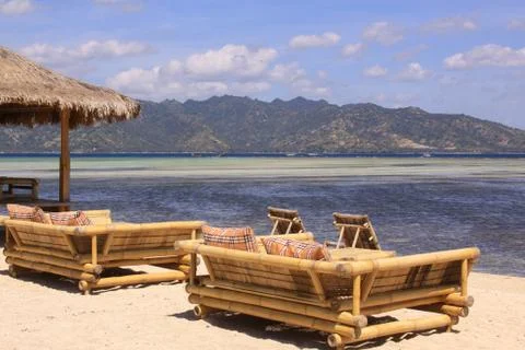 Tropical straw umbrella and sofas at beach bar Foto stock