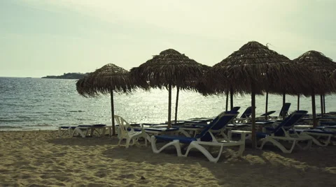 Tropical summer beach setting,bamboo umbrellas,deck chairs Stock Footage 49565642