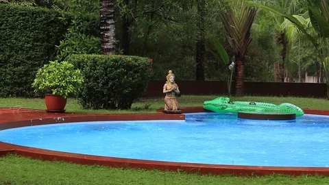 Tropical summer rain falling big rain drops falling down on swimming pool Stock Footage 69857689