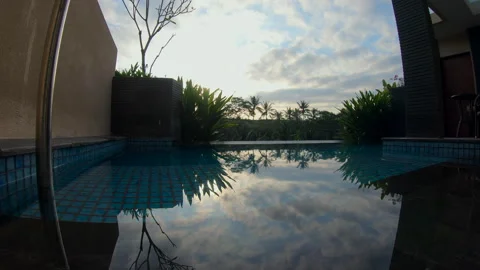 Tropical Sunrise Through Clouds Over Balinese Pool Stock Footage 332581241