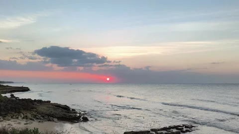 Tropical Sunset Over Rocky Beach with Calm Ocean Waves and Colorful Sky Stock Footage 341505538