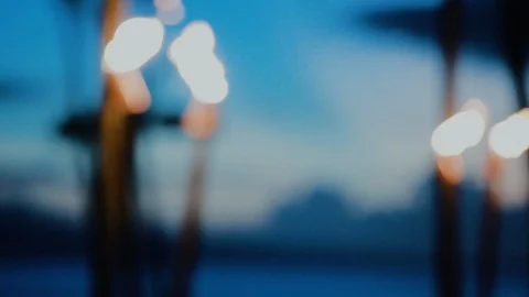 Tropical torch lanterns with flame burning in the evening on the beach of resort Stock Footage 101121850