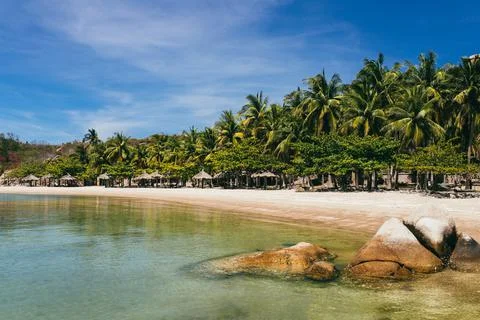 Tropical vacation concept. empty sandy beach with calm sea, clear blue skies Stock Photos