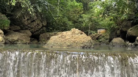 Tropical Waterfall Cascading into Clear Pool, Lush Green Jungle, Panning Shot Stock Footage 324272717