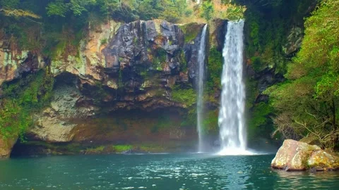Tropical waterfall cascading into a serene forest pool in Southeast Asia Video stock 342820767