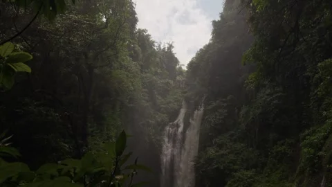 Tropical waterfall flowing down lush green jungle cliff Vídeo Stock 340845536