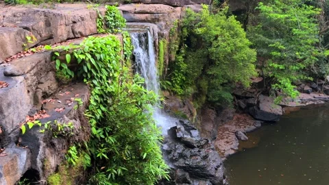Tropical waterfall flowing through rocky jungle cliffs in Southeast Asia Video stock 336662842