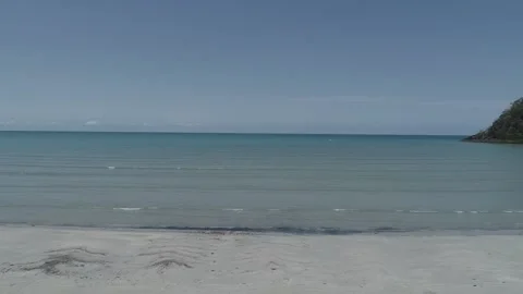 Tropical waves gently lapping on beach - slow flyover Stock Footage 142982425