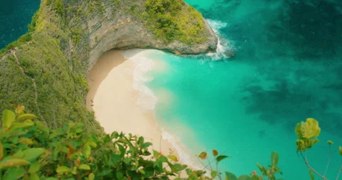 Tropical white sand cove surrounded by steep cliffs at Kelingking beach Bali Stock Footage 344914118