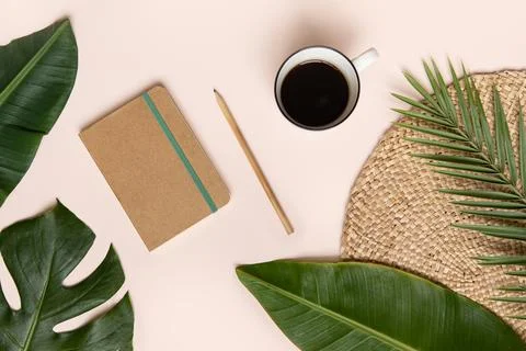 Tropical workspace concept. Notepad and tropical palm leaves. Mockup Stock Photos