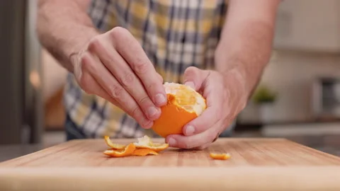 Trouble Peeling an Orange in a Kitchen Close Up Video stock 155111707