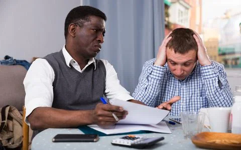 Troubled man discussing documents with partner at home Foto stock
