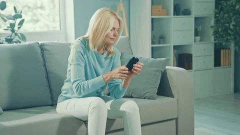 Troubled retired lady sit sofa experience remote control break Video stock 166903237