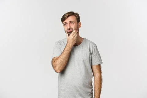 Troubled sad guy touching beard, looking at upper left corner thoughtful Stock-Fotos
