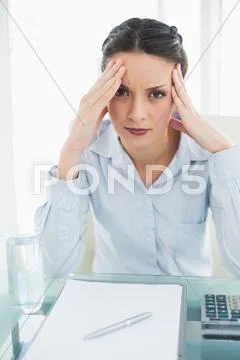 Troubled stylish brunette businesswoman holding her head and looking at camera Stock Photos