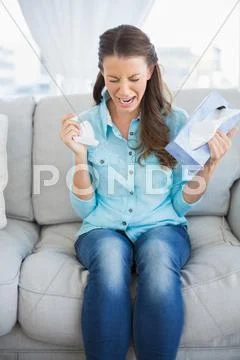 Troubled woman crying sitting on sofa Stock Photos
