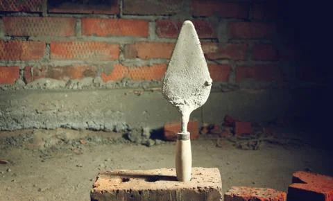 Trowel on a brick wall background Stock Photos