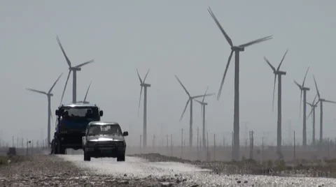 Truck and jeep pass Chinese wind farm Stock Footage