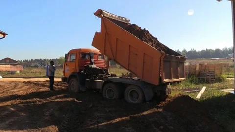 Truck bring soil to land plot near timber house under construction Stock Footage 83241708