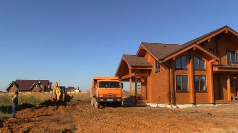 Truck bring soil to land plot near timber house under construction Vídeos de archivo 83241729