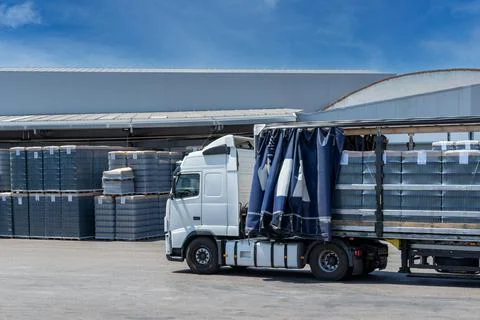 Truck with the canvas open loading pallets of empty glass bottles Stock Photos