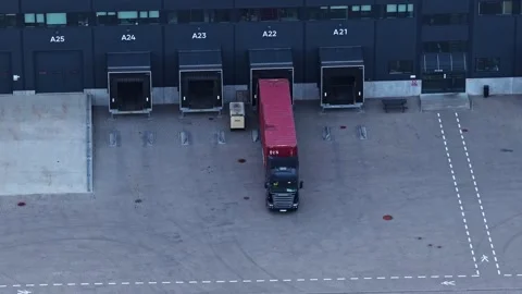 Truck with cargo container reversing into a warehouse loading dock for unloading Stock Footage 337791191