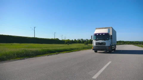 Truck with cargo trailer driving on empty highway transporting goods at summer Video stock 296215596