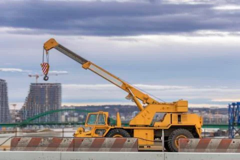 Truck crane construction with dramatic cloudy sky on the bridge in the city Stock Photos